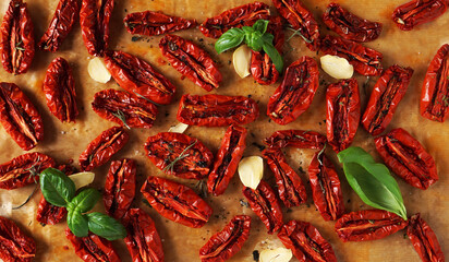 homemade sun-dried tomatoes with garlic slices and basil leaves