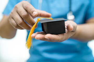 Asian doctor study learn with graduation gap hat in hospital ward, clever bright genius education medicine concept.