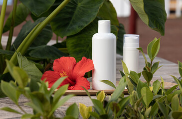 Skin care concept with white bottle and palm leaves on tropical background.