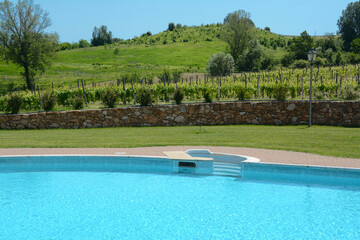 The blue and the luxury of a swimming pool in a villa between the hills and vineyards of the Langhe in Piedmont.