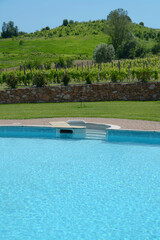 The blue and the luxury of a swimming pool in a villa between the hills and vineyards of the Langhe in Piedmont.
