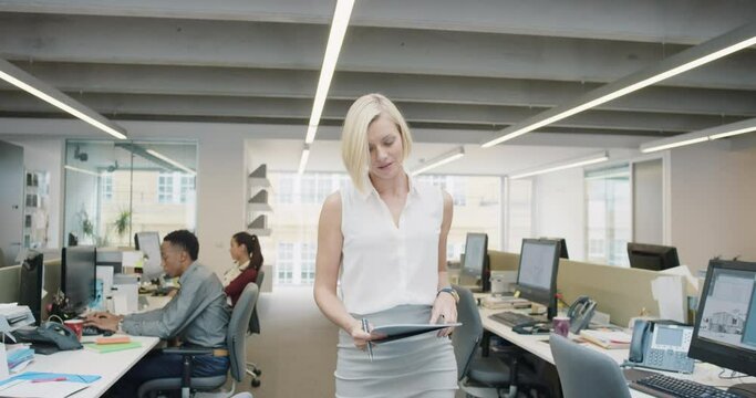 Business power woman leader walking through busy  corporate office planning her next success strategy