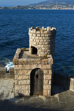small tower of granite stones overlooking the bay of Baiona and with the town of Nigr&aacute;n in the background