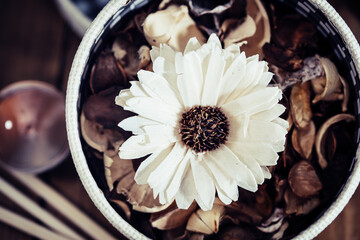 Ethnic style piece of furniture, with round box containing flower and dried petals