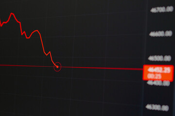 The red line chart shows the declining trend of crypto coins ETH, BTC. Chart of crypto-currency online on the laptop screen.