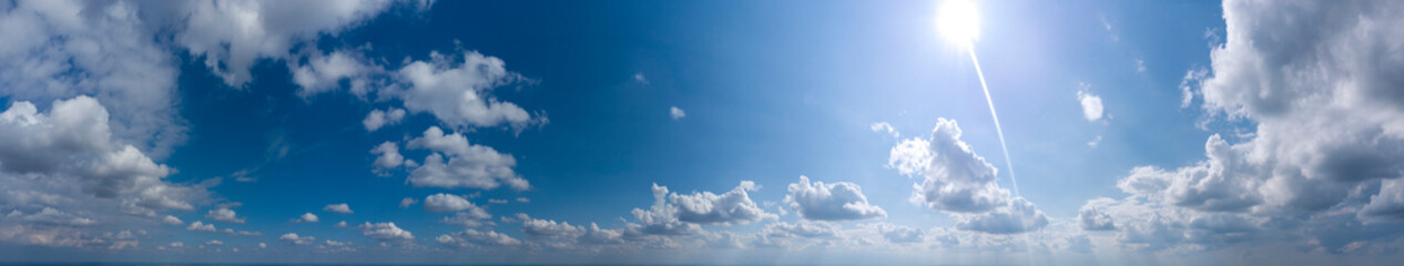 panorama of blue sky with clouds and sun