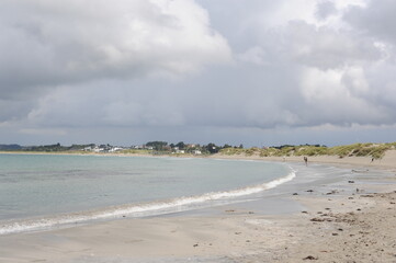 Sola sand beach at the North Sea coast in Stavanger, Norway with a blue sky and white clouds and waves in summer