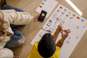 Directly above shot of mother showing smart phone to son at home