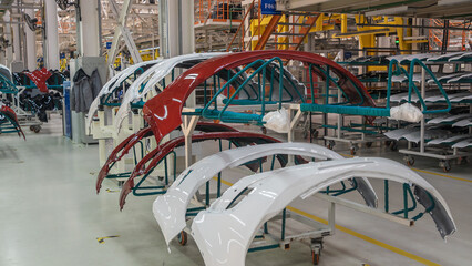 Auto bumpers parts are installed on the racks after painting in the car factory. Industry concept.