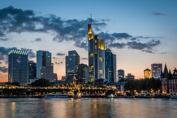 Fototapeta na wymiar Illuminated skyline of Frankfurt at the bank of Main river after sunset
