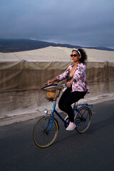 South American woman rides a bike along the beach