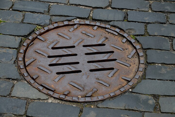 Manhole Cover on an Old Cobbled Village Street