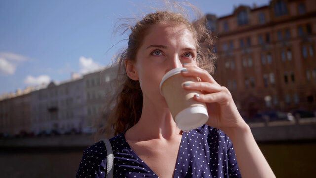Young woman drinking takeaway coffee outdoors
