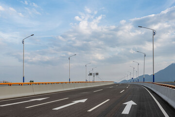 Fototapeta premium Empty asphalt highway road with city skyline.