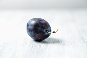 Fresh plums. Fruits. On a white wooden background. Copy space.