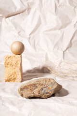 Fototapeta na wymiar Podium for packaging presentation and cosmetic of natural beige color. Stone podium and dry flower