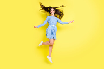 Fototapeta na wymiar Photo of charming sweet young lady wear dotted outfit smiling jumping high isolated yellow color background