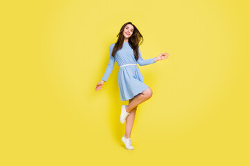 Fototapeta na wymiar Photo of sweet charming young lady wear dotted outfit smiling dancing isolated yellow color background