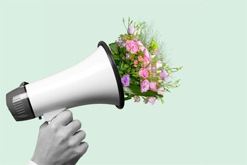 Megaphone with bouquet with blooming spring fresh flowers on pastel background.
