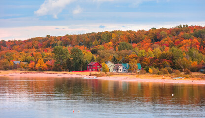 Colorful homes at the Lake Superior shore surrounded by Fall foliage in Michigan - Powered by Adobe