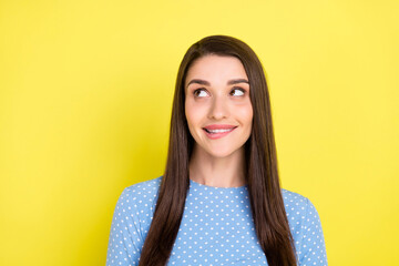 Fototapeta premium Photo of curious tempting girl bite lip look empty space wear dotted blue dress isolated yellow color background