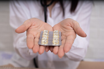 Female doctor shows capsule in blister pack in her hand