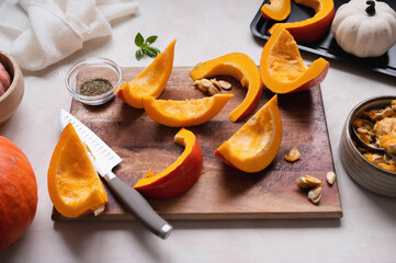 Top view of fresh, orange pumpkin slices on cutting board. Cooking ingredients for a butternut soup, pie or autumn foods.