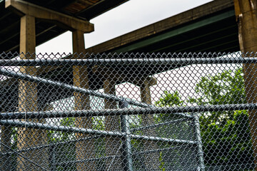 View of security chain link fences and highway overpasses overlaid in foreground and background. 