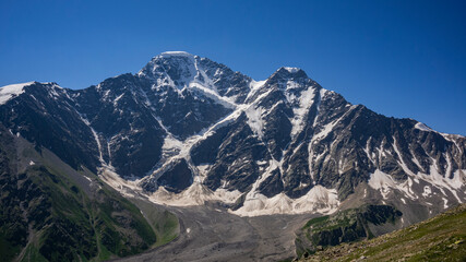Part of Glacier Seven on mount Donguzorun. View from Mount Cheget, Kabardino Balkaria region. Russia. 3000 metres height. Lifting on Cable Car. View on Donguzorun mount. Panorama. - obrazy, fototapety, plakaty