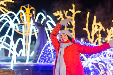 Fototapeta premium Girl in a night city snowflake Christmas city lights. Christmas and winter holidays concept.