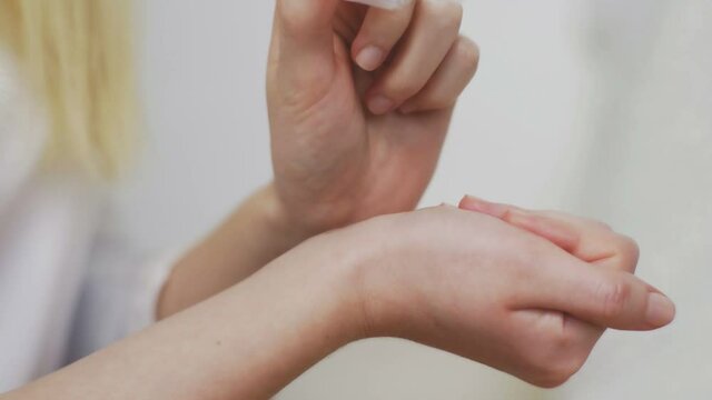 Close-up of an unrecognizable girl applying perfume on her wrist