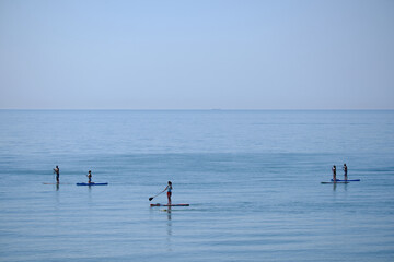 A group of stand up paddle boarders on a calm sea in Eastbourne.