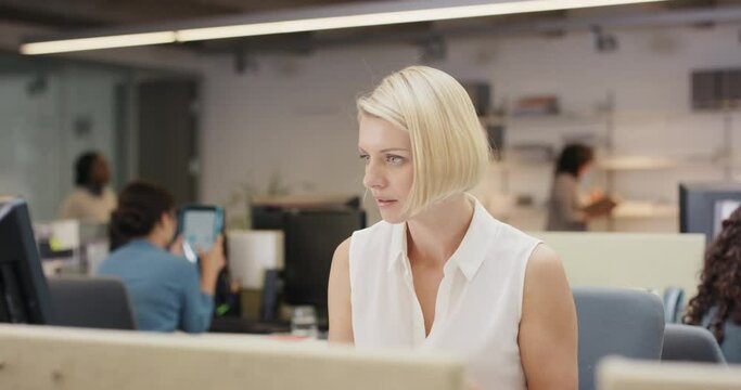 Powerful Businesswoman executive working at computer using smart phone connected to global data in busy corporate office