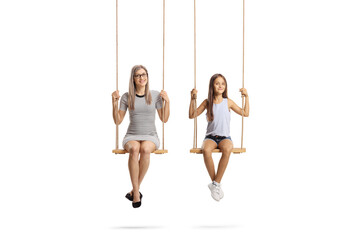 Young mother with her daughter sitting on wooden swings