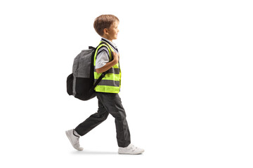 Full length profile shot of a schoolboy in a uniform and safety vest walking