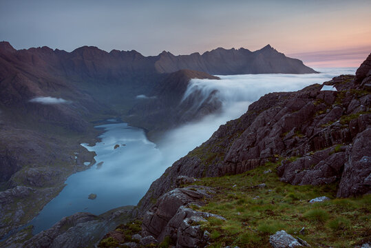 Sunrise at a wild camp on the hills above Loch Coruisk on Skye with a cloud inversion flooding into the glen below, Isle of Skye