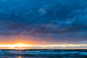 Obraz premium A beautiful, romantic and colorful sunset at the Polish seaside, the Baltic Sea. Beautiful beach and the sun setting in the colorful sky