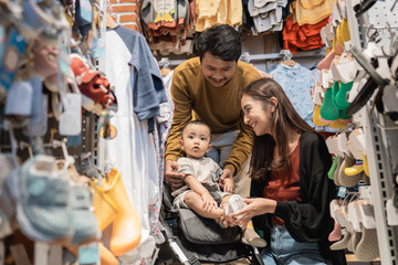 father and mother shopping at the baby shop with their son in the stroller