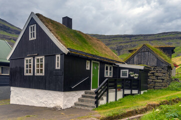 Fototapeta na wymiar Saksun, a charming historical village on the Faroese island of Streymoy. Located in the stunning end of an former inlet (now a logoon) surrounded by high mountains