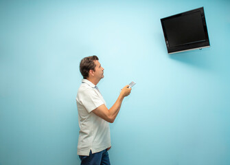 mature man changing television channel with remote control