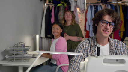 Portrait of happy tailor team smiling at camera in workshop