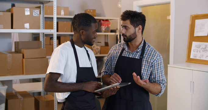 Diverse businessmen check product order on stock working in storehouse - Powered by Adobe