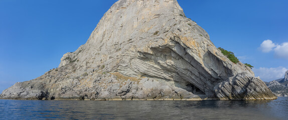 Stony coast of Crimea. Mount Koba Kaya. View from the sea. On the right is a grotto named after...