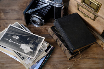 old family photos 50s, 40s, retro camera, books on wooden table, concept of genealogy, memory of...