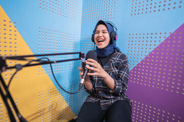 Naklejka premium A vlogger girl is recording a podcast in studio