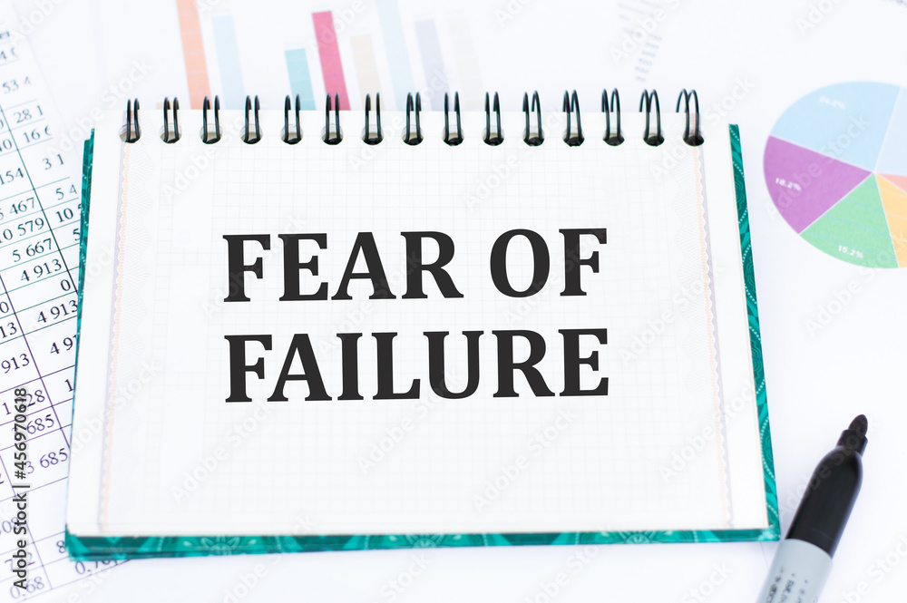 Poster text fear of failure on notepad on color charts.