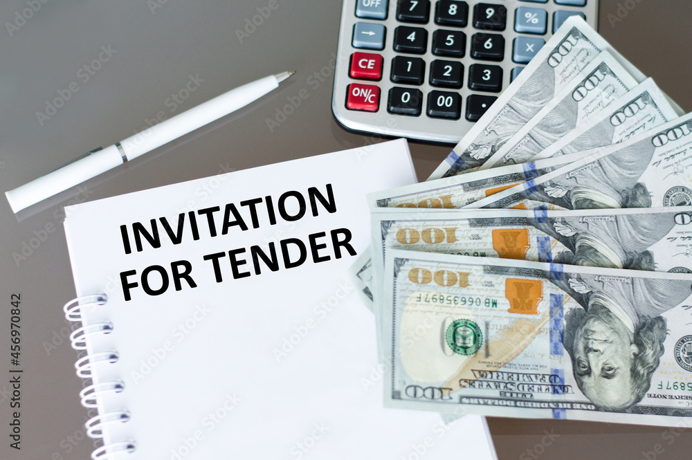 Poster notepad with text invitation for tender on the table next to a calculator and money. business