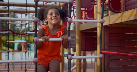 African kid having fun with climbing net outdoors