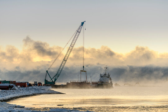 Tug moored to bardge. Strong fog in Arctic sea. Construction Marine offshore works. Dam building, crane, barge, dredger.