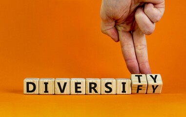 Diversity or diversify symbol. Businessman turns wooden cubes and changes the word 'diversify' to...